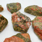 Held in hand, a Unakite raw stone, hand-selected from Northern Cape, South Africa.