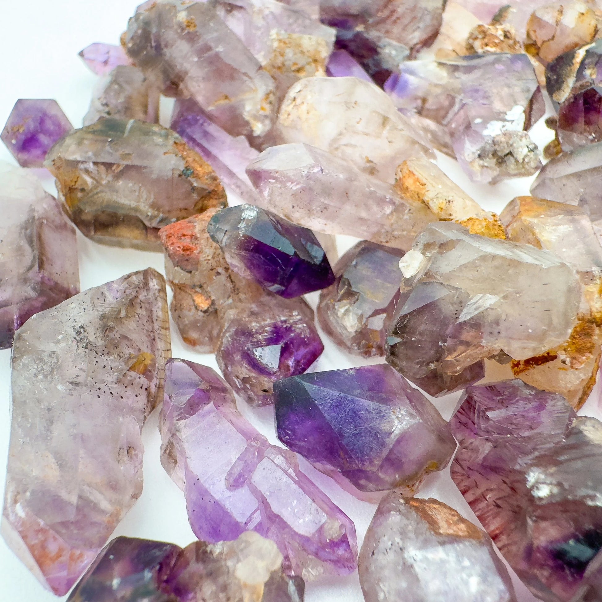 Size comparison with one Smoky Amethyst raw point for scale, Zimbabwe-sourced.