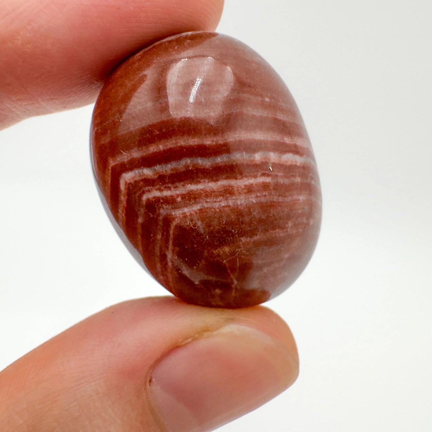 Field-of-view of Red Aragonite tumbled stone, from Junín, Peru, showing the piece in repose.