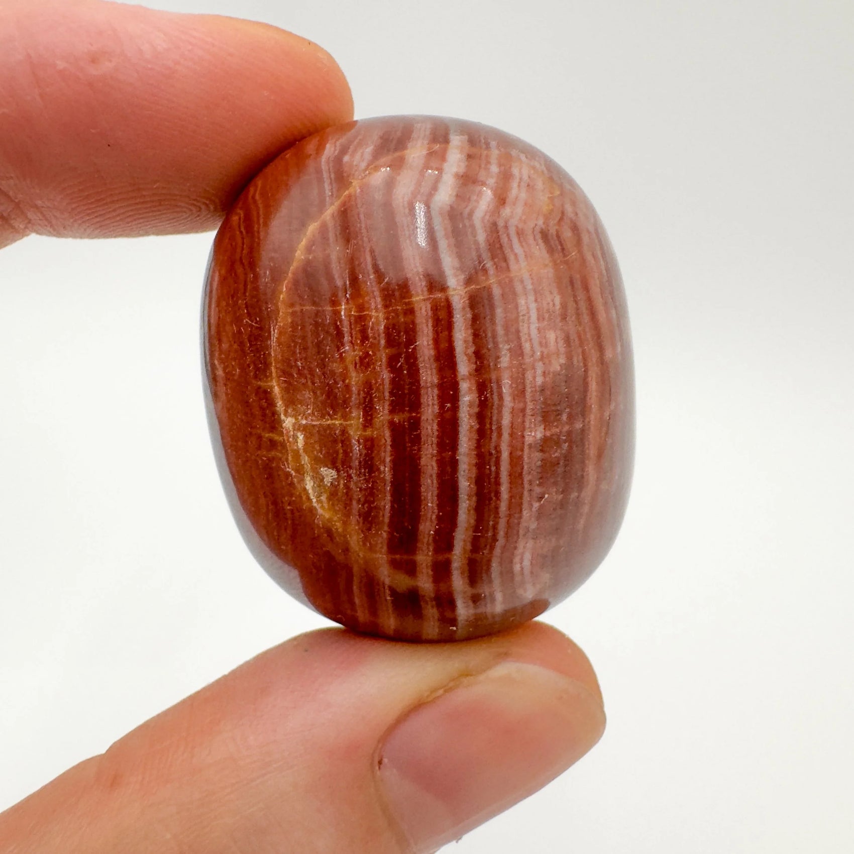 Back view of Grade AAA Red Aragonite tumbled stone showing natural surface