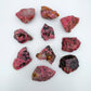 Surface detail of Rhodonite raw stone, often kept for Emotional Healing and Love, showing characteristic color.