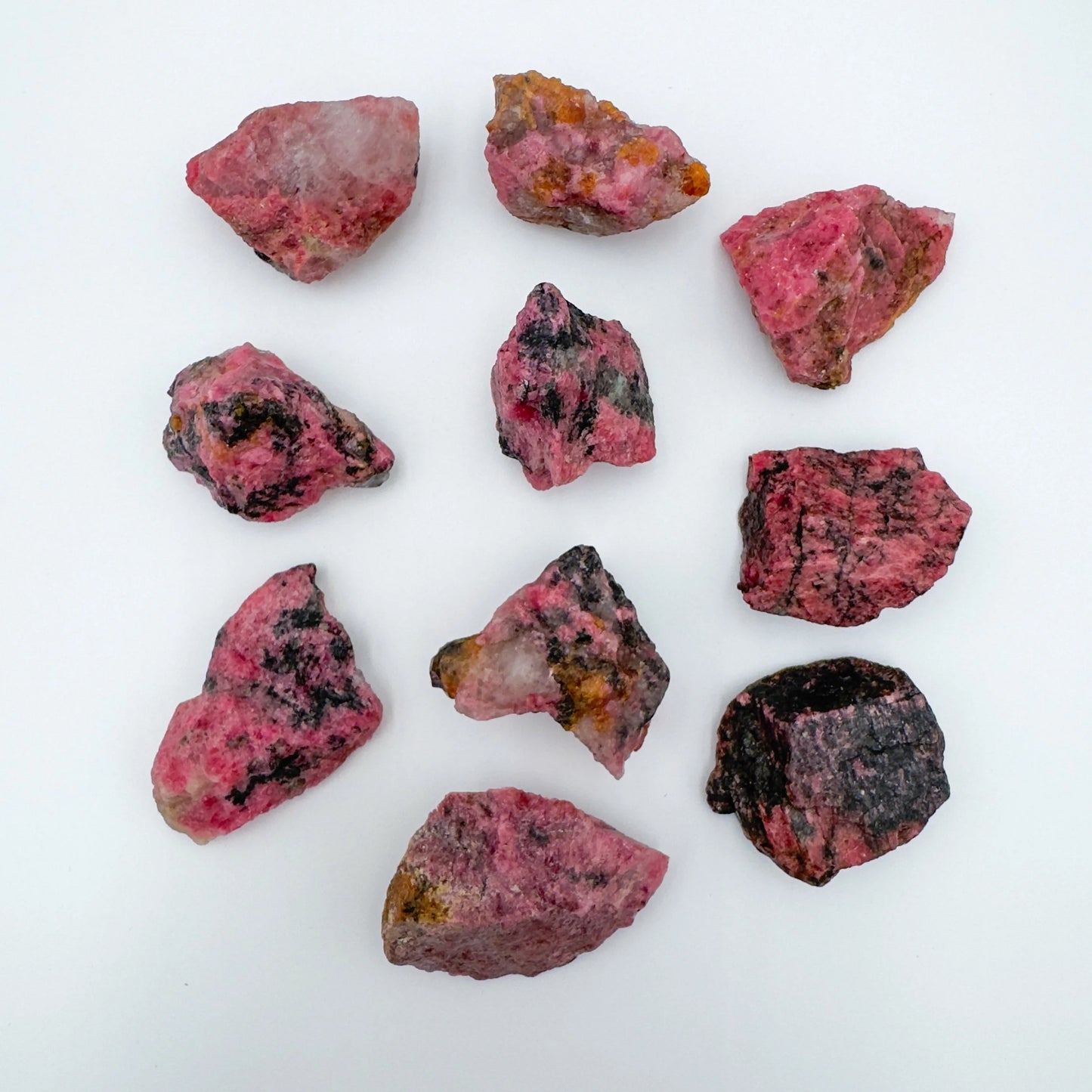 Surface detail of Rhodonite raw stone, often kept for Emotional Healing and Love, showing characteristic color.