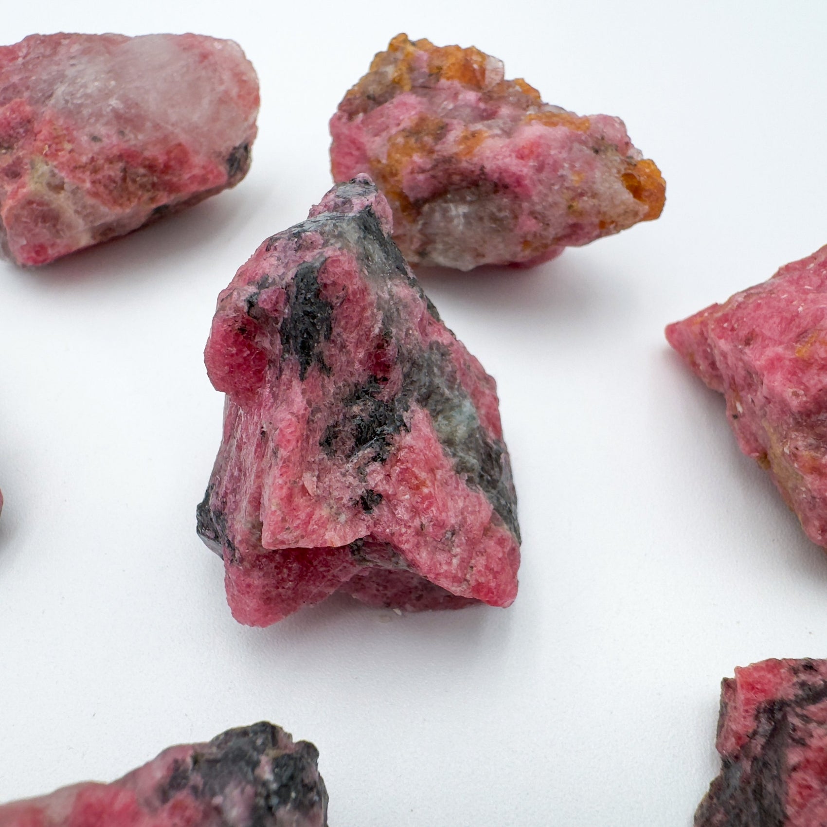 Close-up of Rhodonite raw stone from Zimbabwe, soothing wellness stone for Emotional Healing