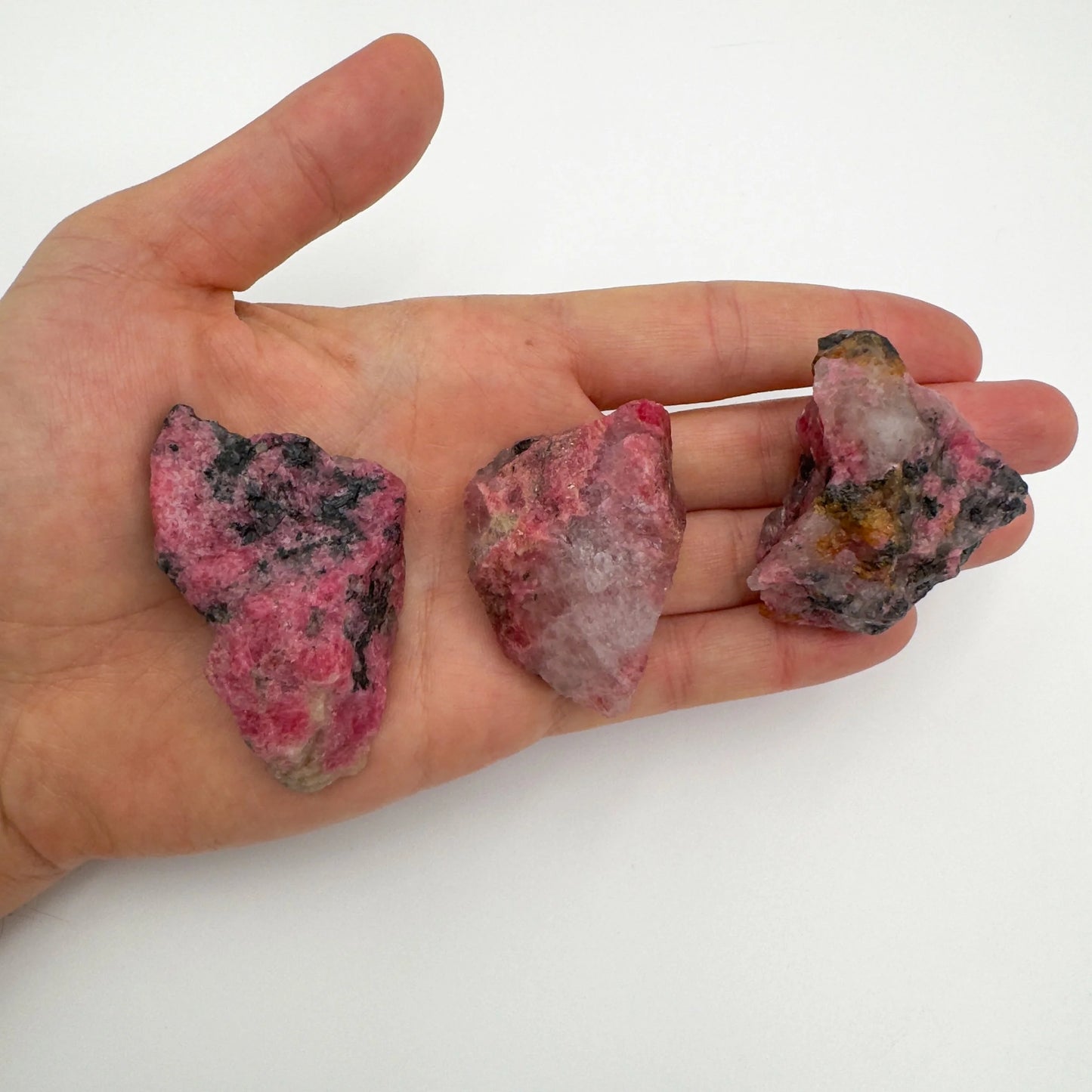 Back view of Grade AA Rhodonite raw showing natural surface