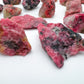 Side-on view of Rhodonite raw stone, sourced from Masvingo, Zimbabwe.