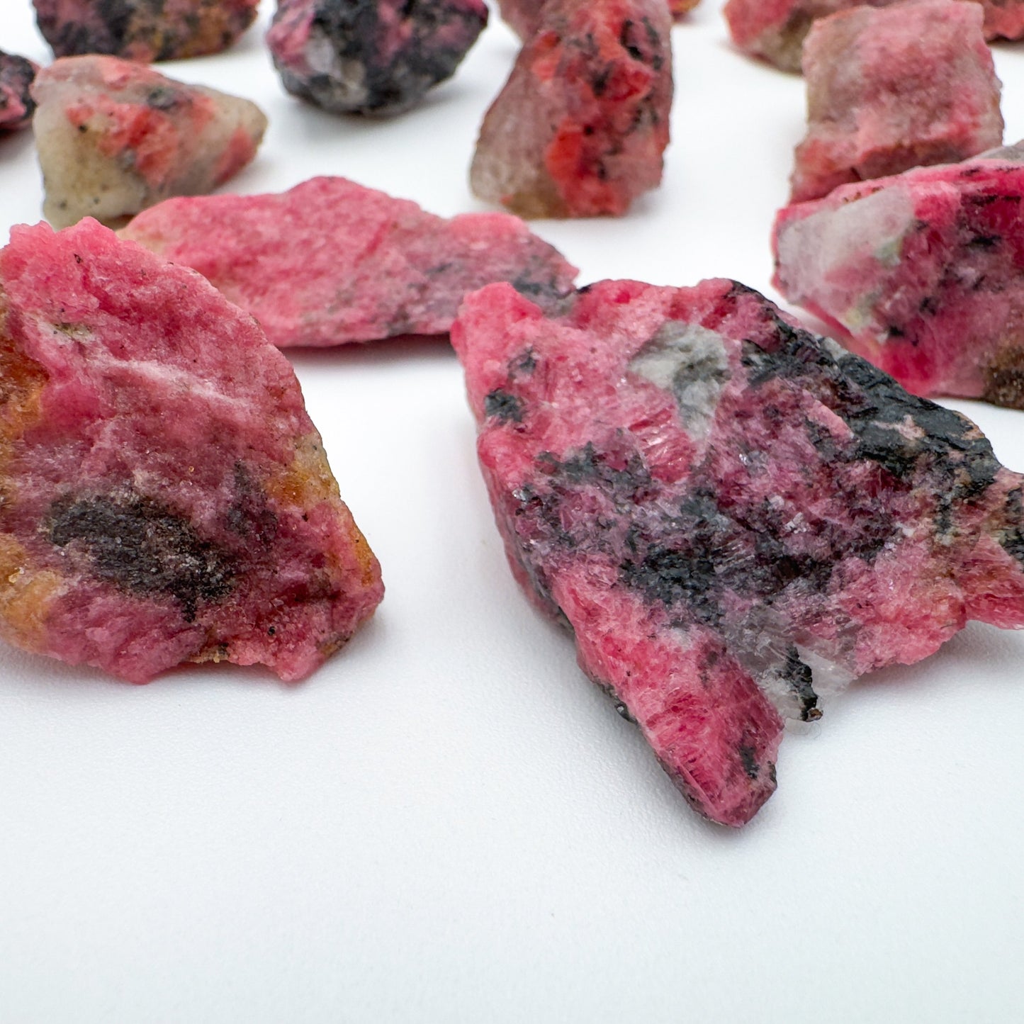 Side-on view of Rhodonite raw stone, sourced from Masvingo, Zimbabwe.
