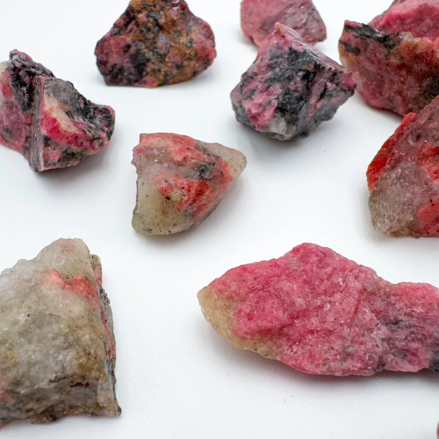 Back view of Grade AA Rhodonite raw stone, associated with Emotional Healing, sourced from Masvingo, Zimbabwe.