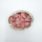 Close detail of pink Rose Quartz tumbled stone, associated with Love, showing natural texture.