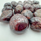 Near view of Garnet tumbled stone, sourced from Minas Gerais, Brazil, showing characteristic color.