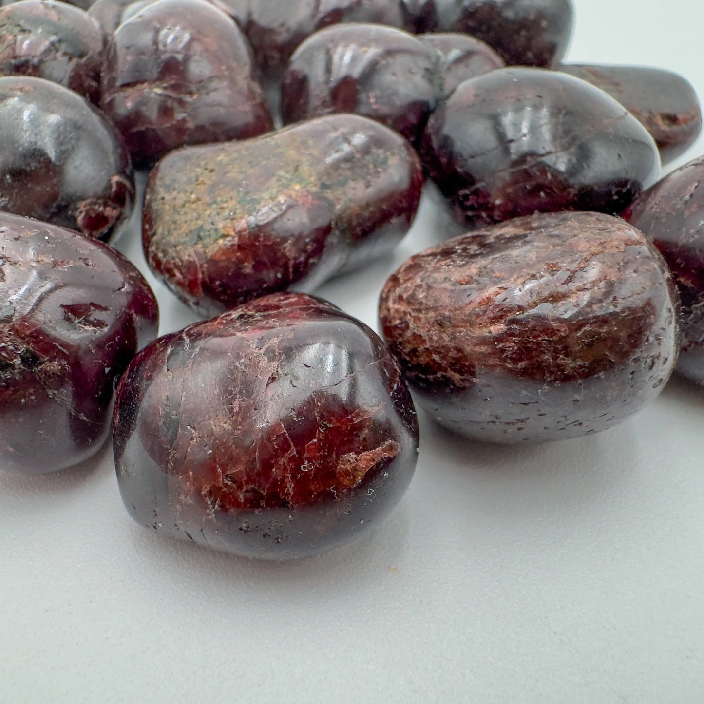 Side profile of Garnet tumbled stone, kept near for Energy and Confidence, showing natural texture.