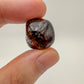 Held in hand, a single Garnet tumbled stone hand-selected from Minas Gerais, Brazil.