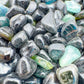 Close-up of Green Tourmaline polished chip, often paired with practices around Healing, sourced from Mozambique.