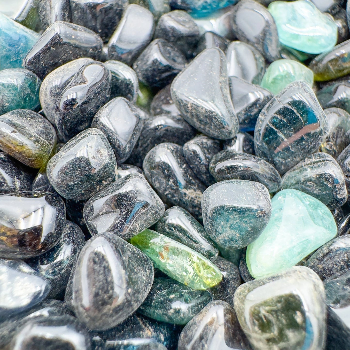 Close-up of Green Tourmaline polished chip, often paired with practices around Healing, sourced from Mozambique.