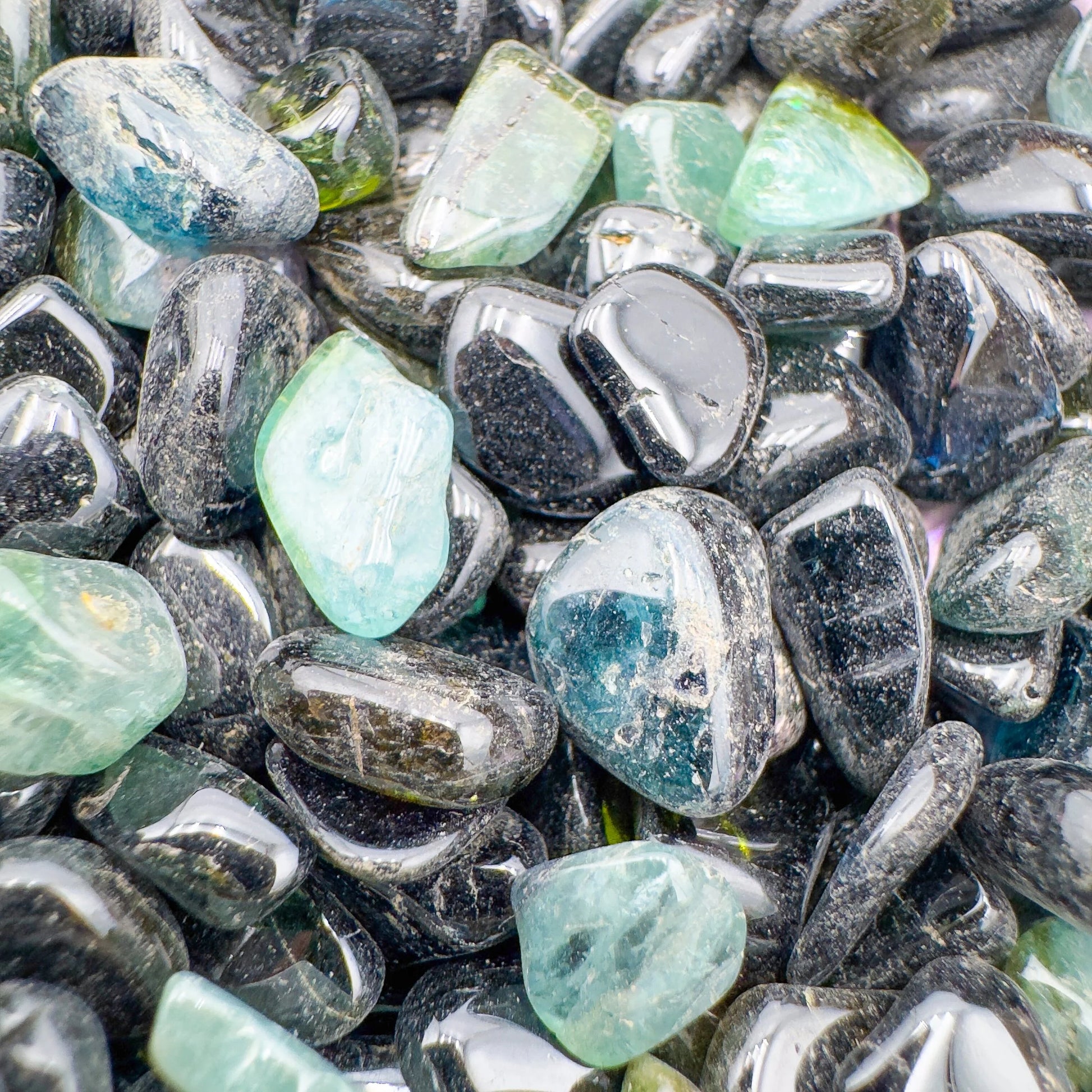 Sideways view of Green Tourmaline polished chip, showing natural sheen, sourced from Nampula, Mozambique.