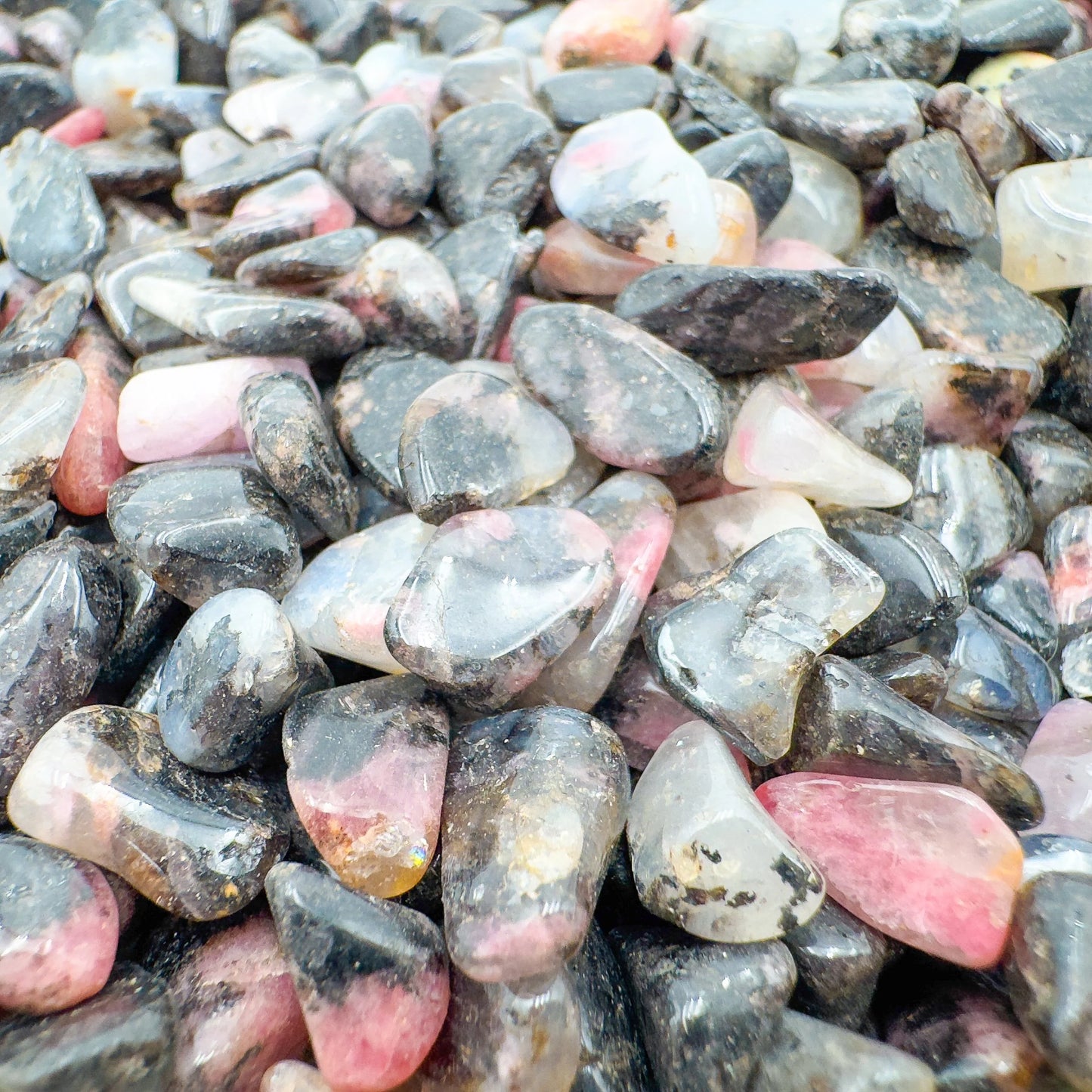 Edge view of Rhodonite polished chip, showing characteristic finish.