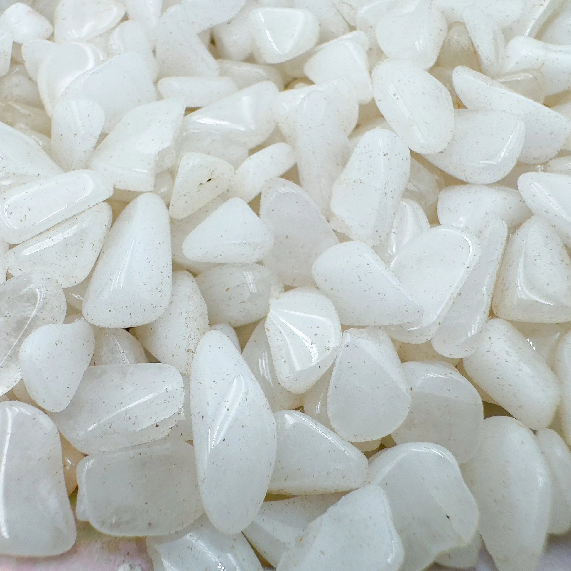 Up-close view of Grade A Snow Quartz polished chip, showing glassy finish.