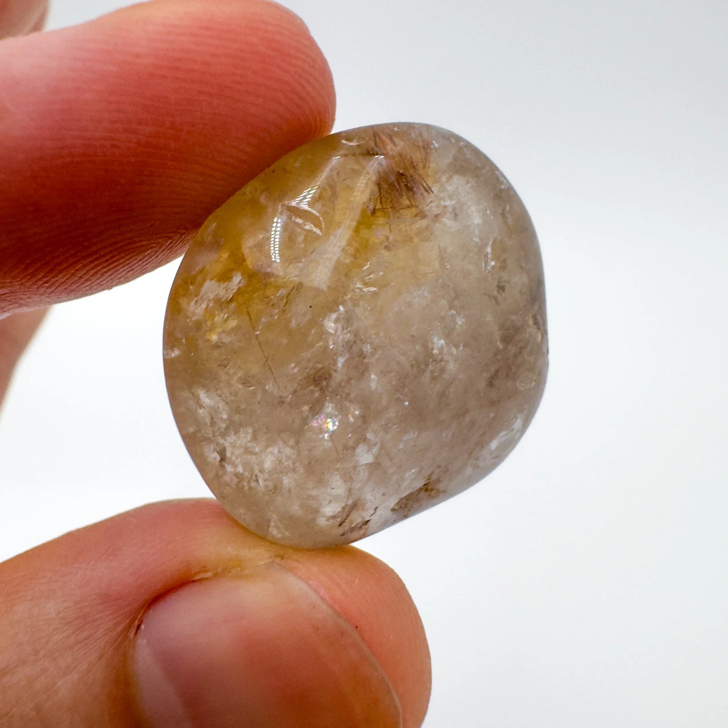 Hand-held view of a Quartz tumbled stone kept close for Cleansing, hand-selected from Minas Gerais, Brazil.