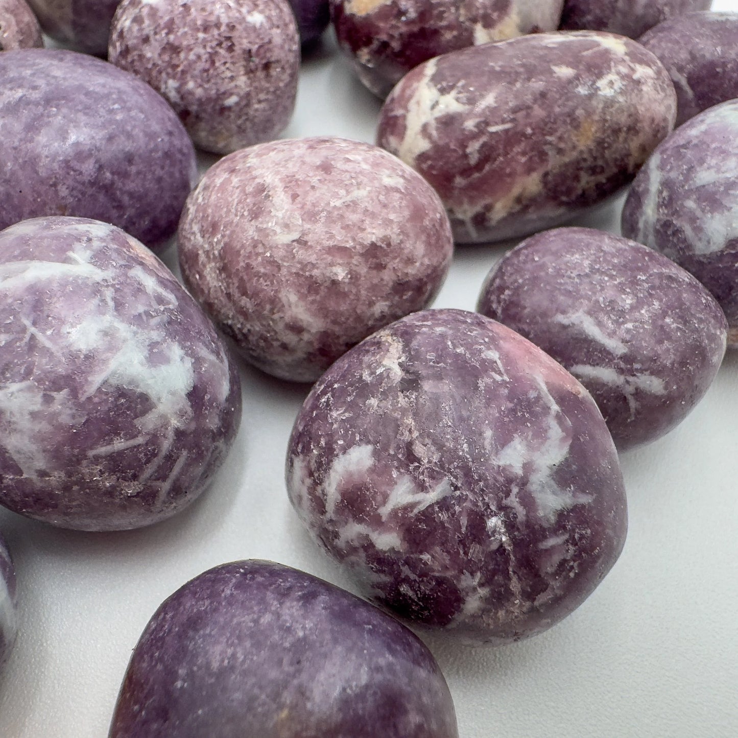 Top view of Lepidolite tumbled stone, showing characteristic finish.