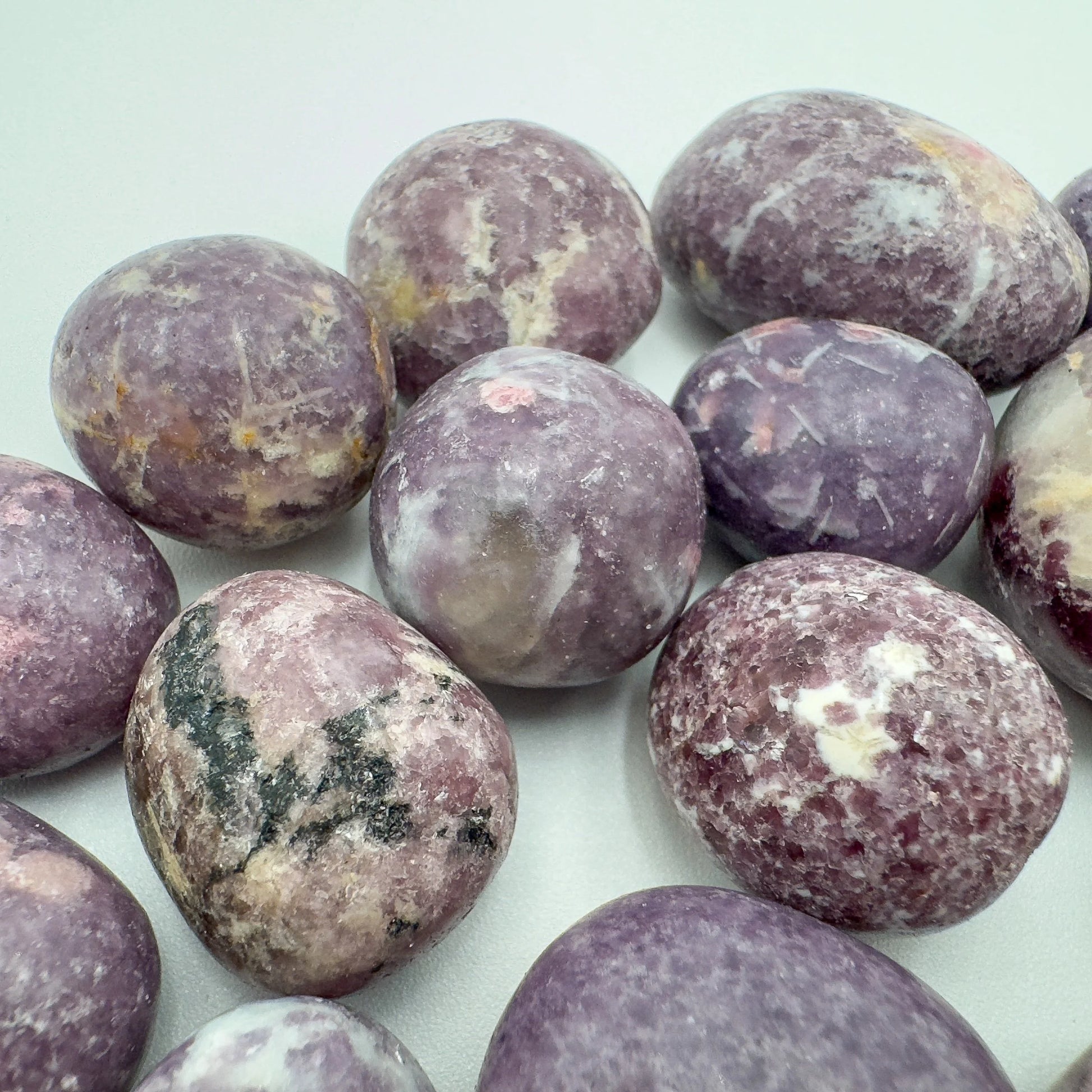 Underside detail of purple Lepidolite tumbled stone, linked to Stress Relief, showing characteristic finish.