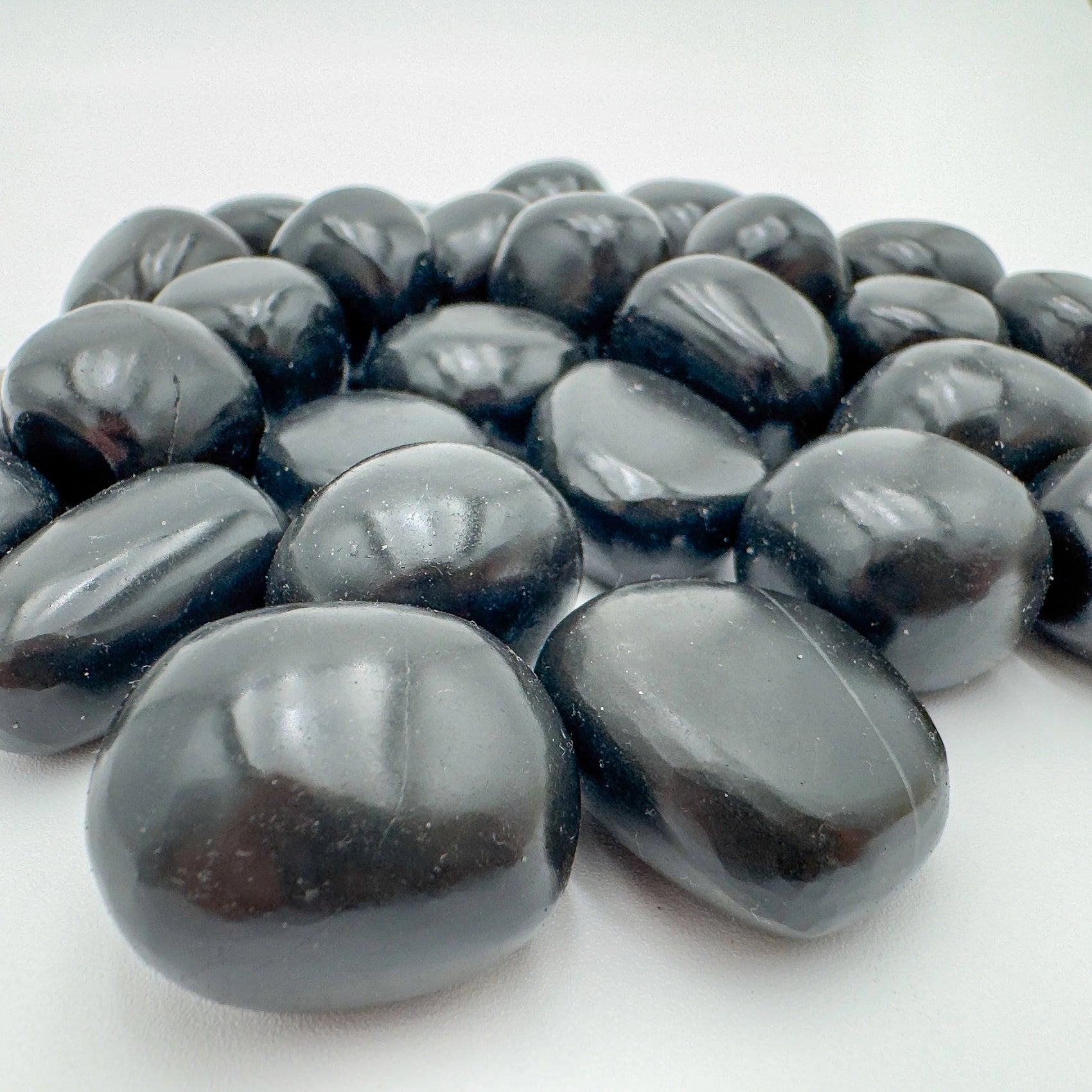 Detail capture of Grade AA Black Onyx tumbled stone, showing natural variation.