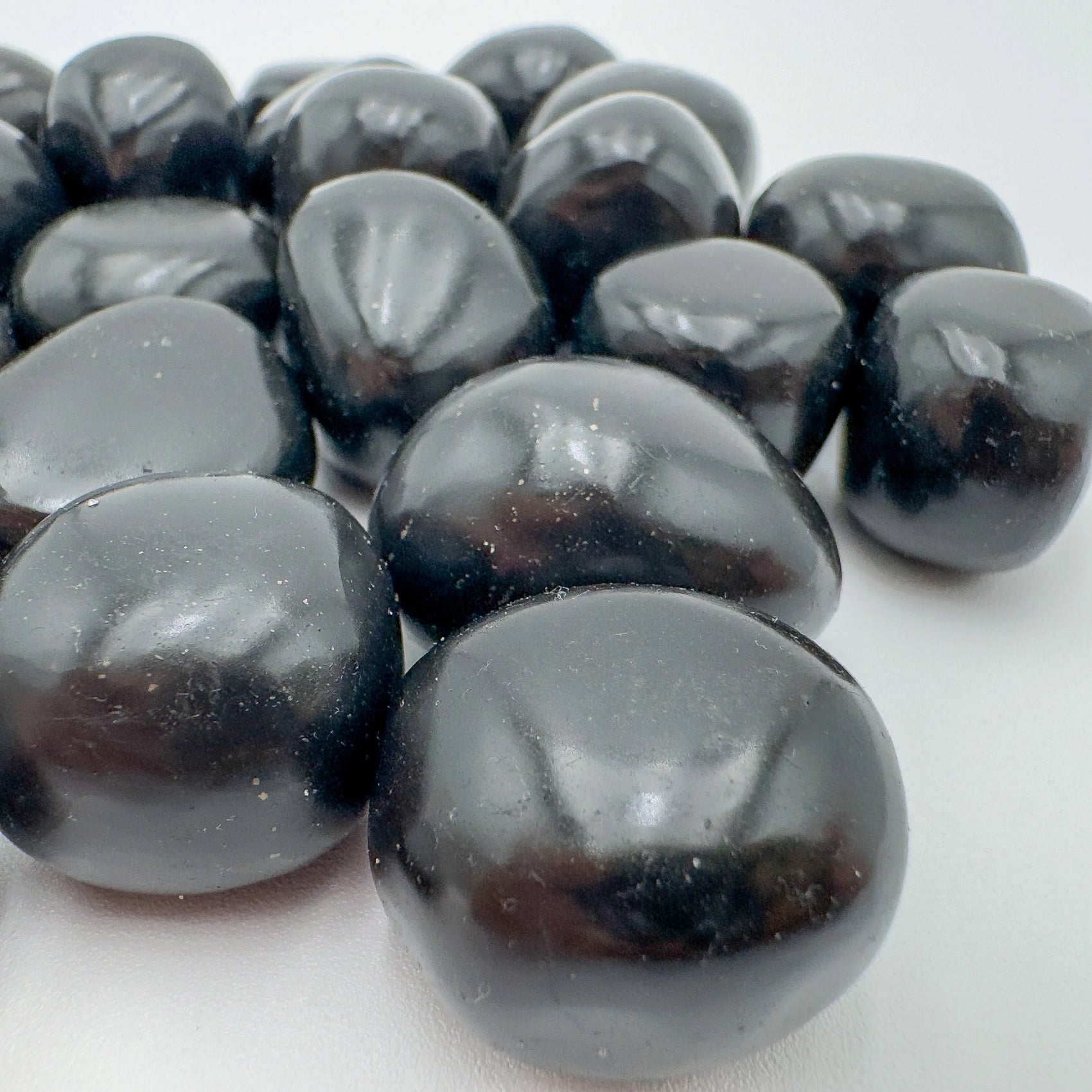 Overhead view of Grade AA Black Onyx tumbled stone, worked with for Protection and Grounding, from Ancash, Peru.