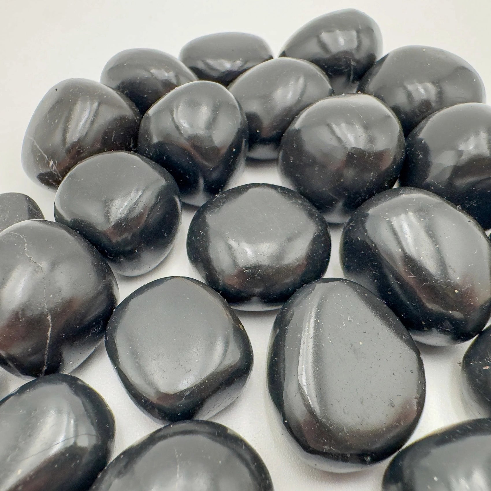 Lateral view of Black Onyx tumbled stone, Peru-sourced, showing subtle veining.