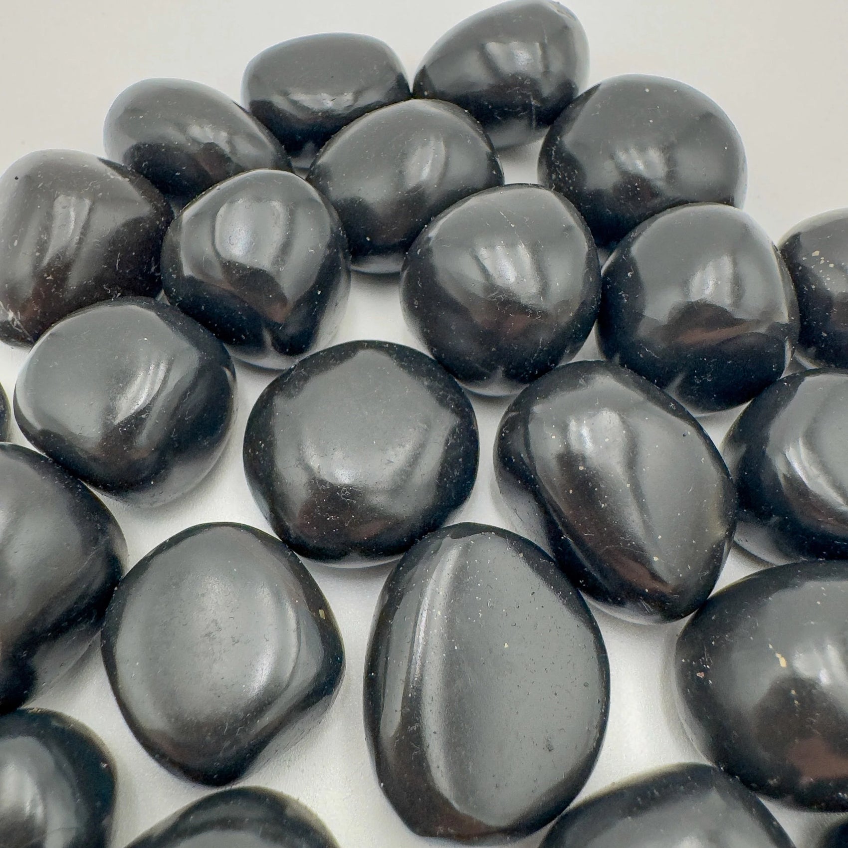Bottom side of Black Onyx tumbled stone, to support Protection and Grounding, sourced from Ancash, Peru.