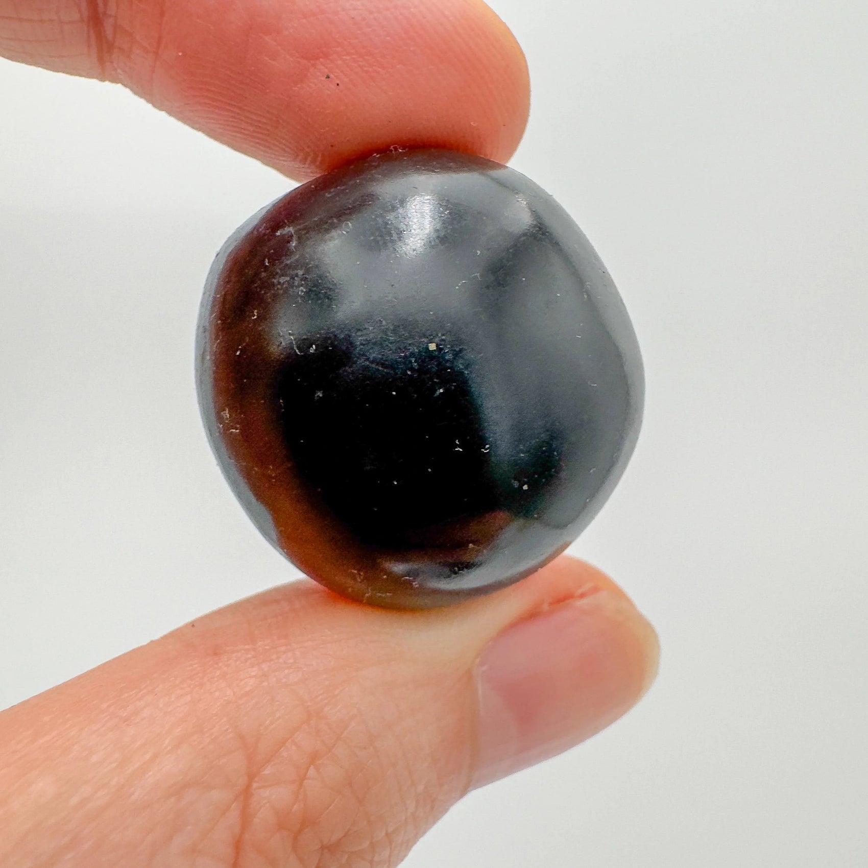 Detail shot of Grade AA Black Onyx tumbled stone under natural light