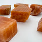 Side profile of Orange Calcite raw stone, sourced from Erongo, Namibia, showing natural texture.