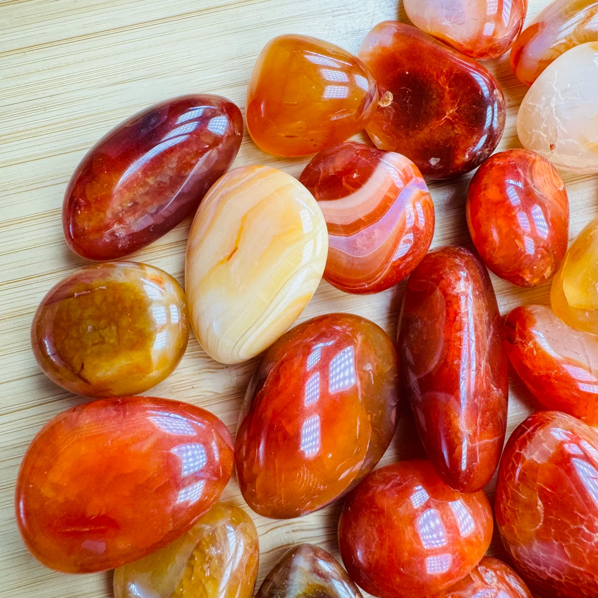Close-up detail of Grade AA Carnelian tumbled stone showing natural orange, red tones and texture