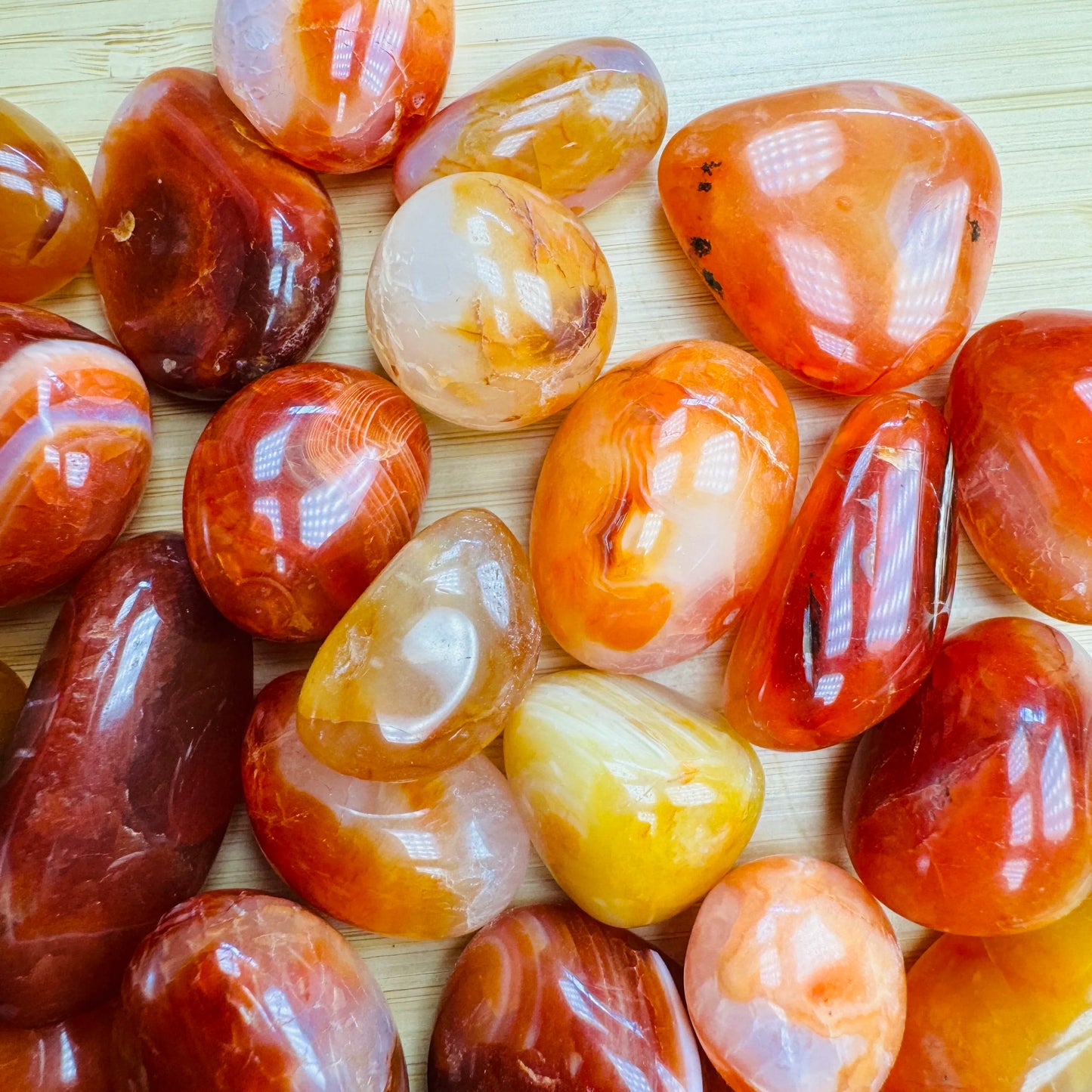Side profile of Grade AA Carnelian tumbled stone with natural form and inclusions