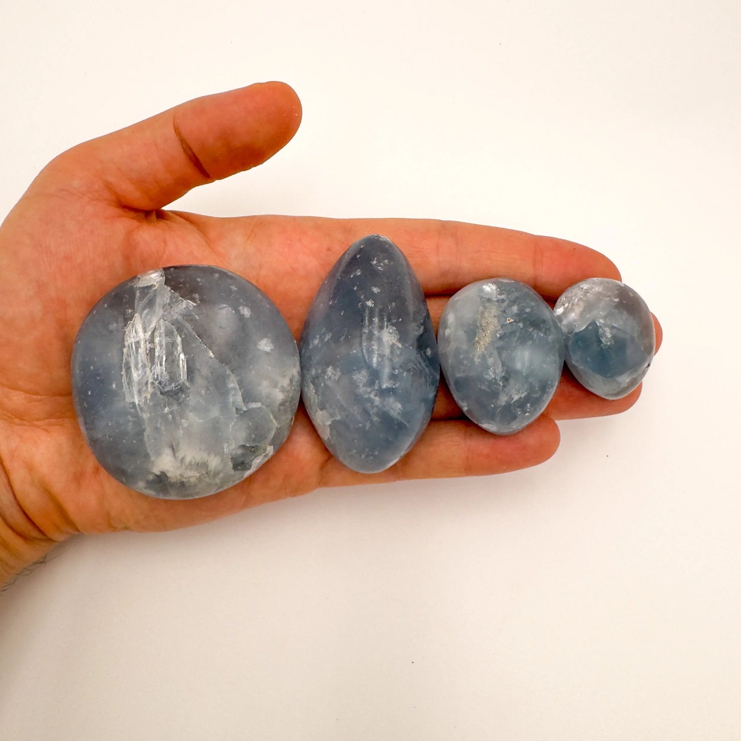 Celestite palm stone from Madagascar with Blue, Clear color, polished finish for mindful calm