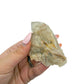 A hand holds citrine cluster no. 22 for scale, the 0.27 lb specimen sitting across the palm at 3.45 inches.