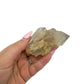 A hand holds citrine cluster no. 27 for scale, the 0.27 lb specimen sitting across the palm at 2.58 inches.