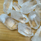 Side profile of Clear Quartz raw point, showing subtle veining, to support Cleansing.