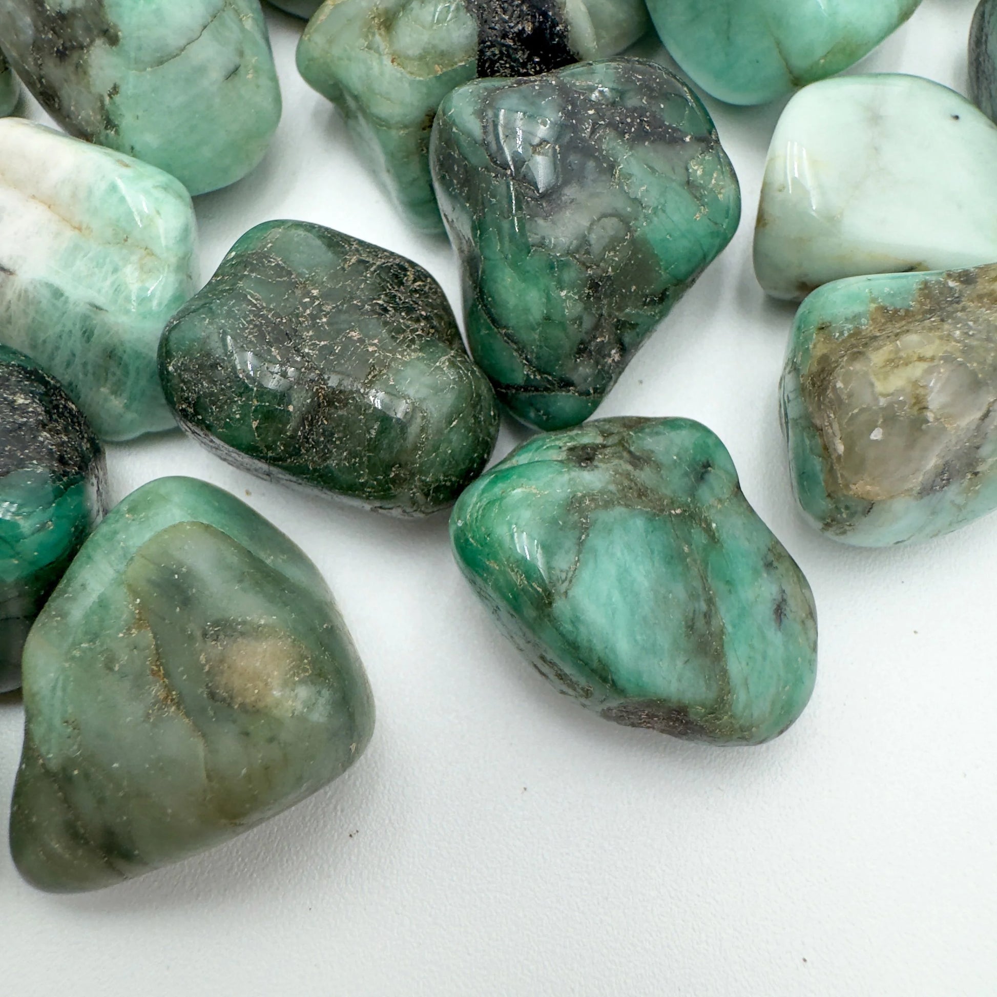 Bird's-eye view of Emerald tumbled stone, sourced from Brazil, showing characteristic patterning.