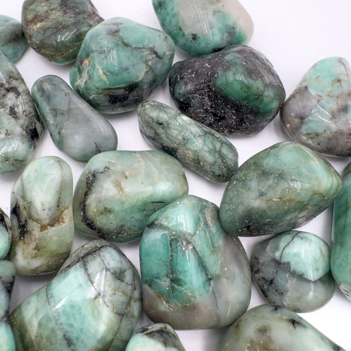 Scale reference of one Emerald tumbled stone for scale, from Bahia, Brazil.