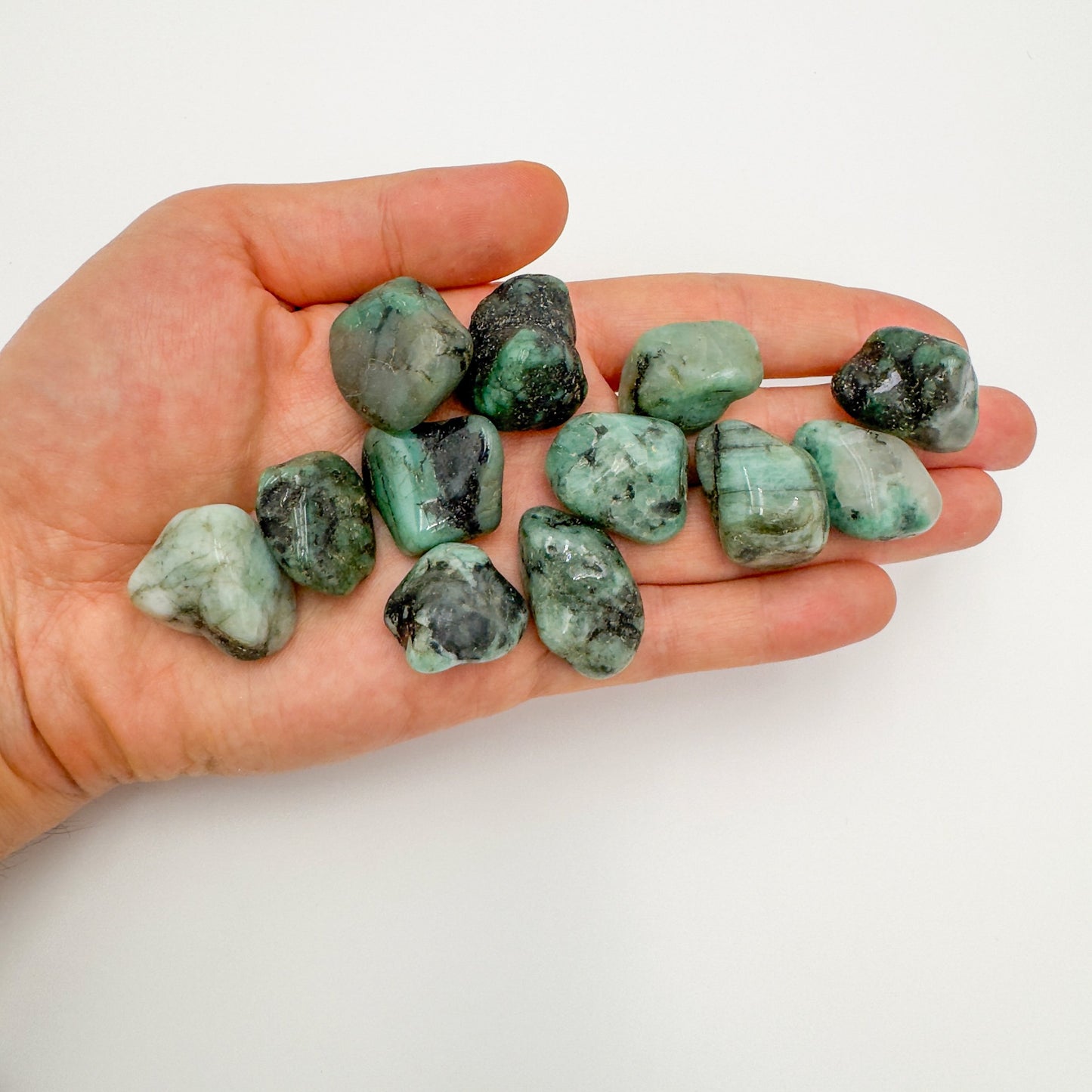 In context of an Emerald tumbled stone, from Bahia, Brazil, shown for size reference.