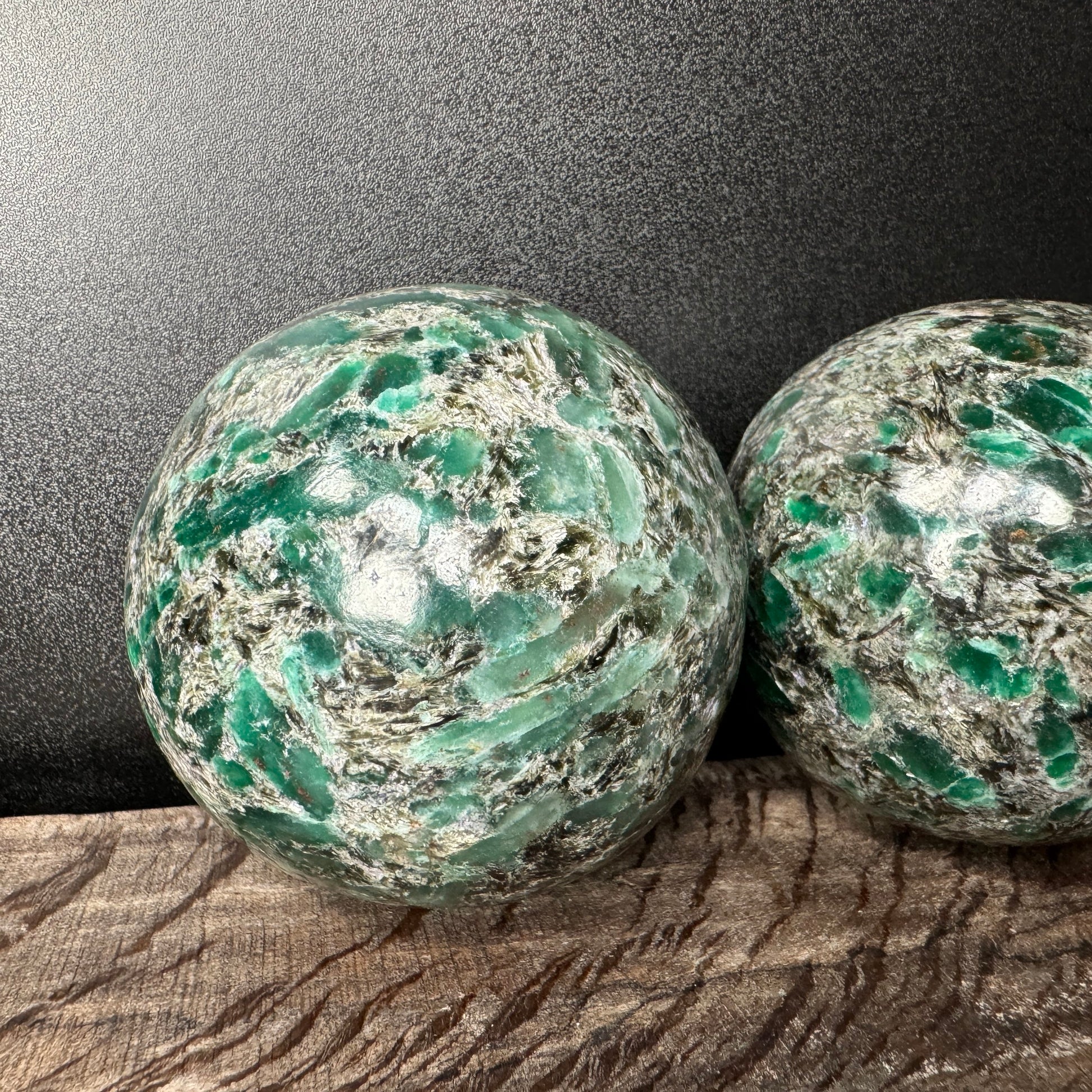 Back view of Grade AA Emerald sphere showing natural surface