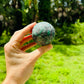 Natural light view of a Emerald polished sphere kept close for Love.
