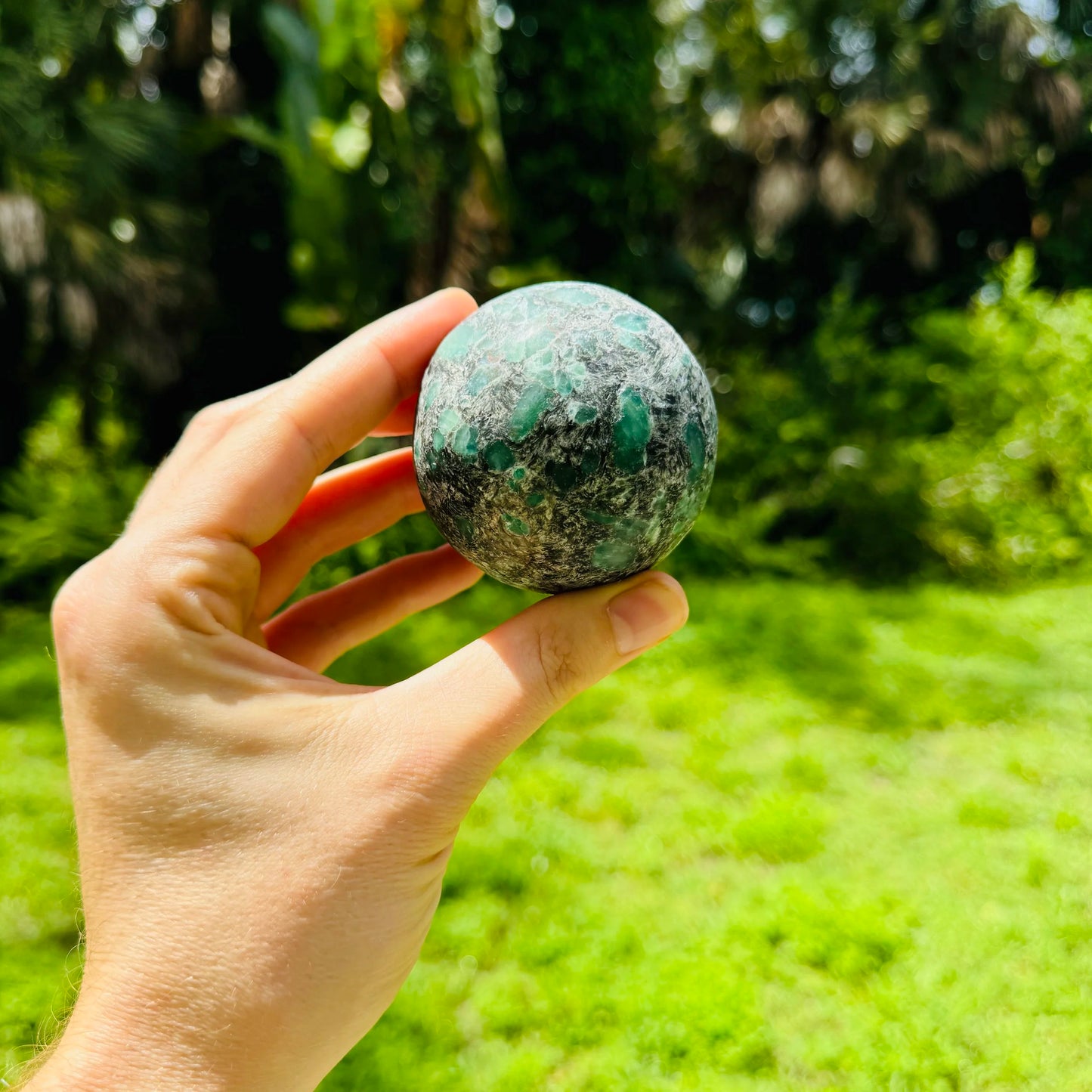 Natural light view of a Emerald polished sphere kept close for Love.