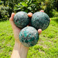 Profile shot of Emerald polished sphere, showing natural texture, drawn on for Love and Abundance.