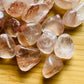 Detail shot of Grade AA Fire Quartz tumbled stone under natural light
