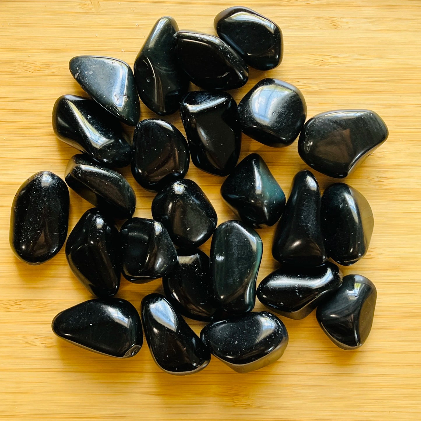 Back view of Grade AA Rainbow Obsidian tumbled stone showing natural surface