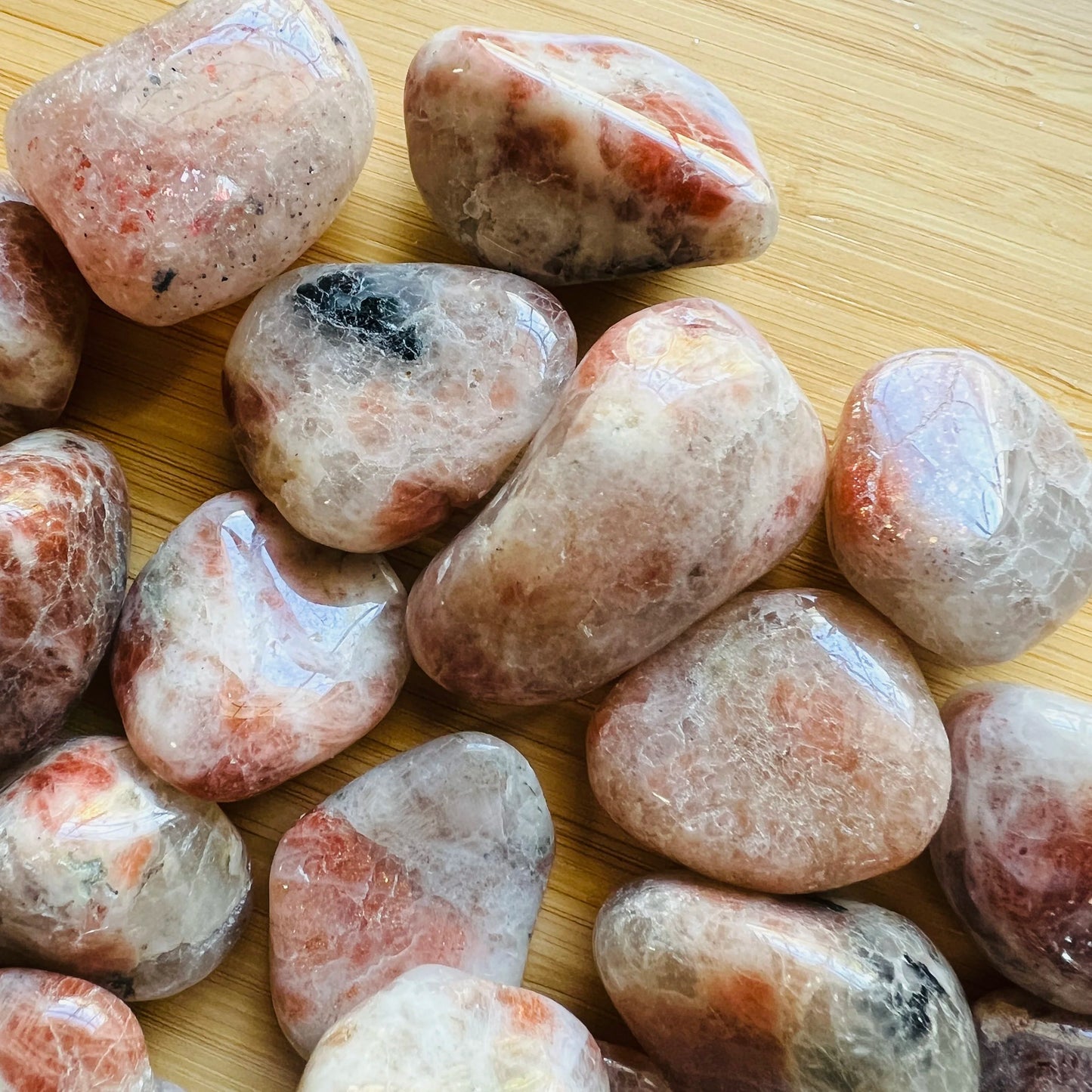 Reverse side of orange Sunstone tumbled stone, showing subtle veining, sourced from Morogoro, Tanzania.