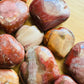 Bottom side of Petrified Wood polished heart, showing natural inclusions.