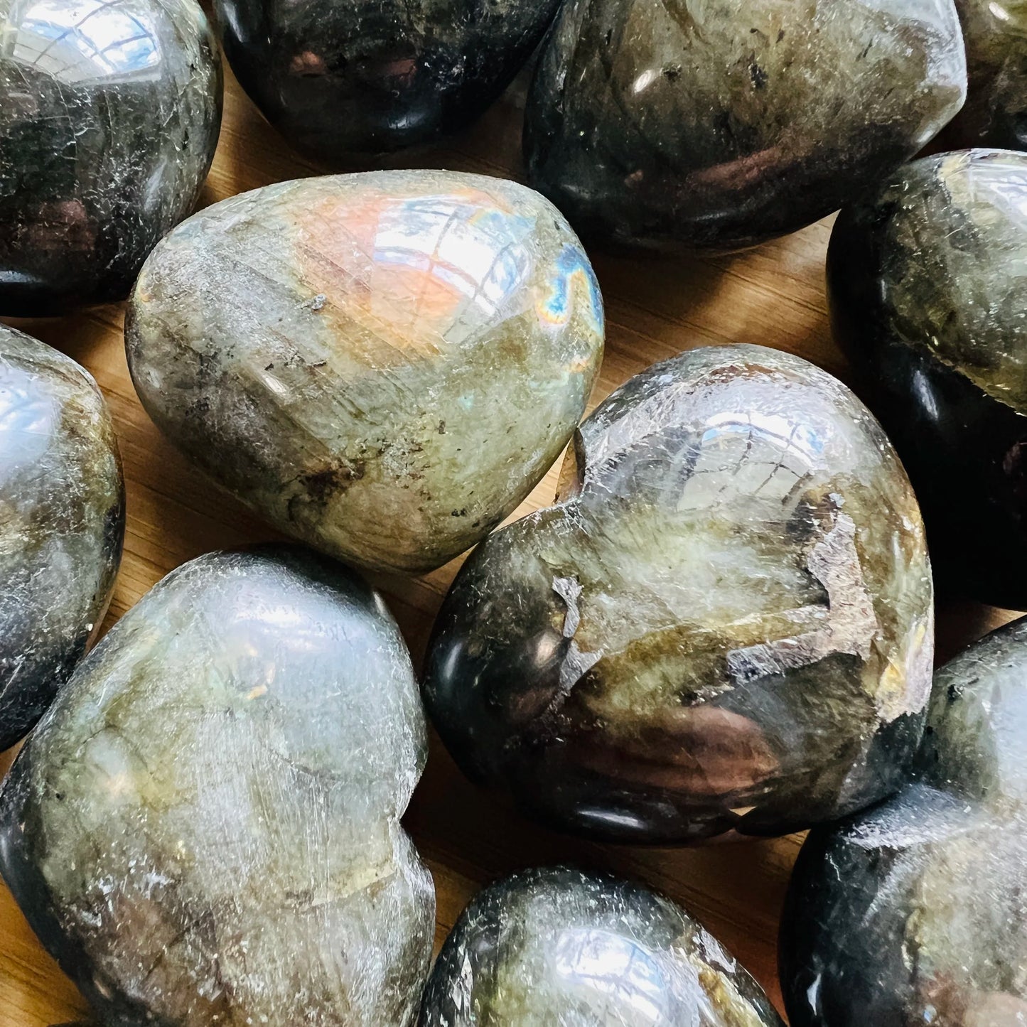 Full piece view of Labradorite stone, from Atsimo-Andrefana, Madagascar, shown for proportion against the hand.