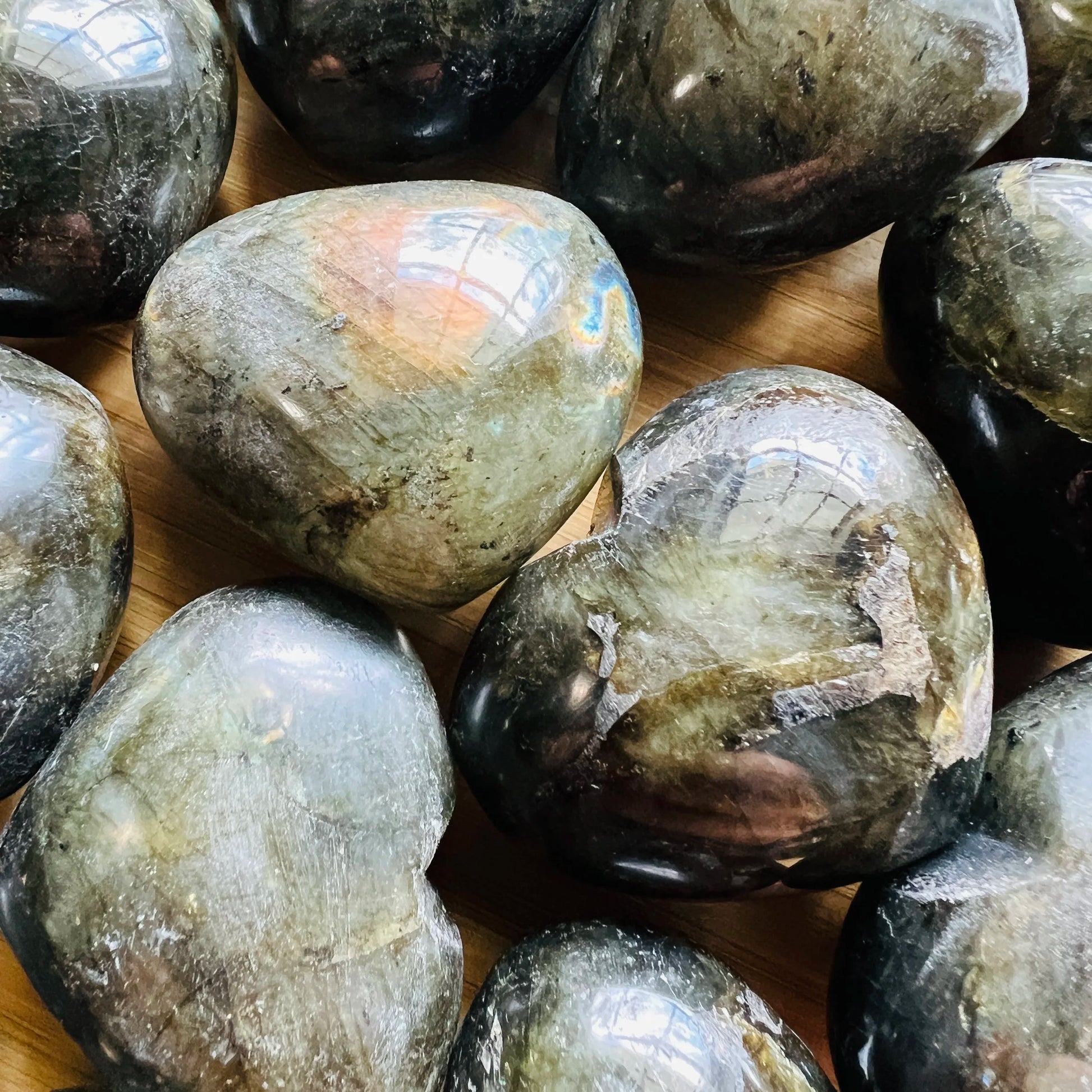 Full piece view of Labradorite stone, from Atsimo-Andrefana, Madagascar, shown for proportion against the hand.