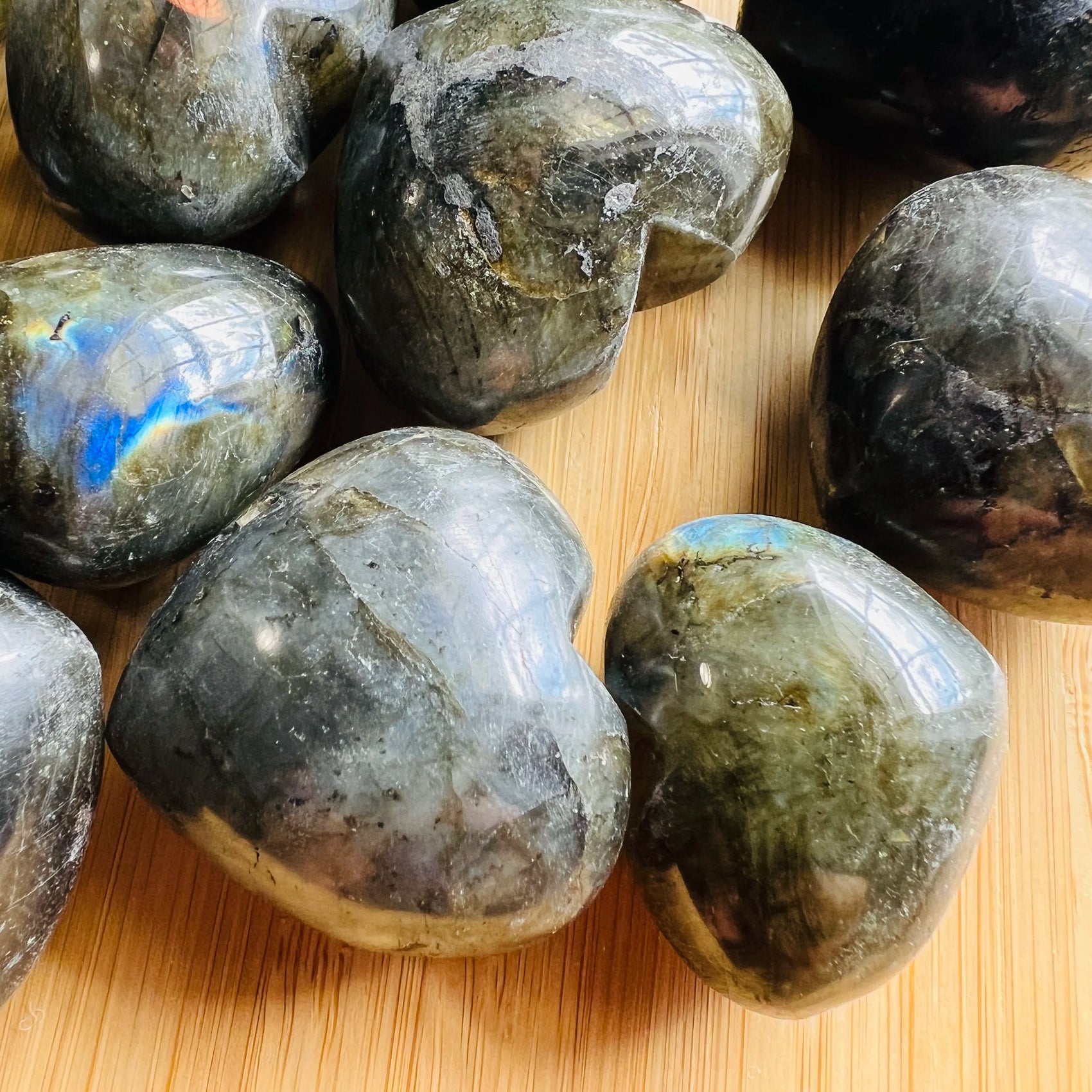 In-hand view of a single Labradorite polished heart from Madagascar.