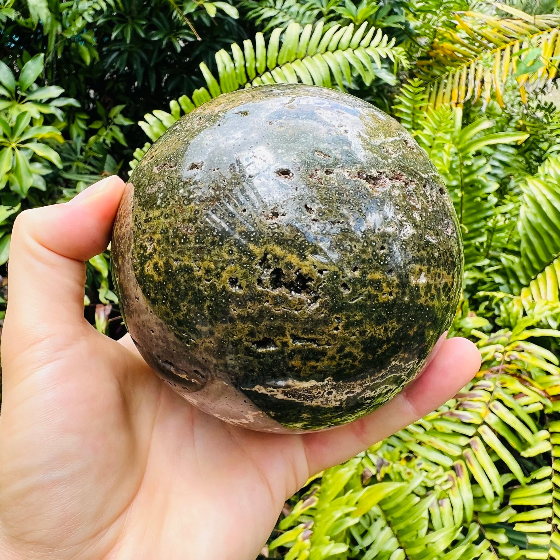 Hand-held view of one Ocean Jasper polished sphere for scale, from Madagascar.